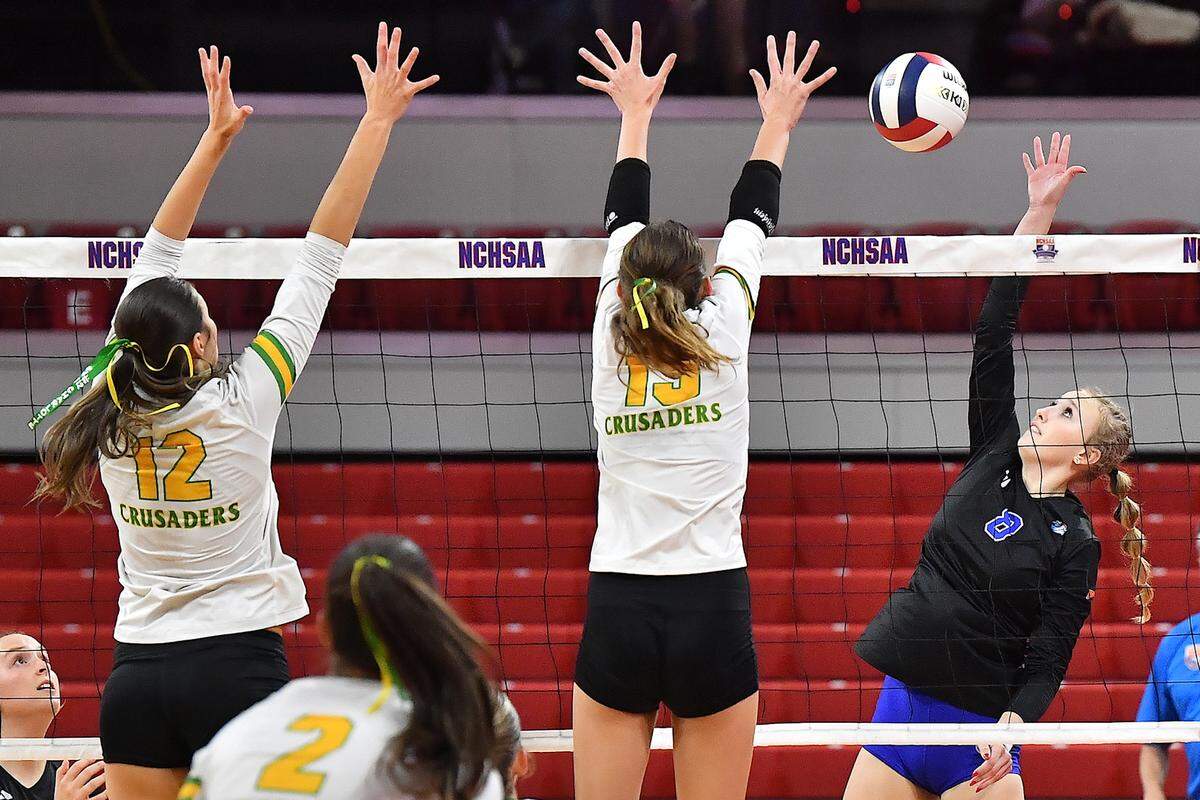 Marvin Ridge’s Ashley Murray (8) spikes the ball against Cardinal Gibbons’ Katherine Barbour (19) and Mary Grace Gonyeau (12) in the NCHSAA n4A Championship game. The Marvin Ridge Mavericks took on the Cardinal Gibbons Crusaders in the NCHSAA 4A Volleyball Championship match in Raleigh, N.C. on November 2, 2024.