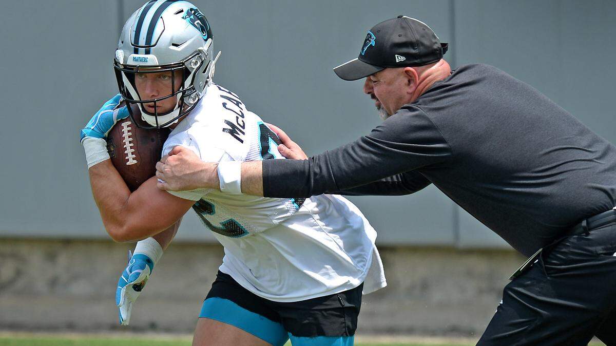 Carolina Panthers running back Christian McCaffrey protects the ball as he runs through a drill during the teamÕs OTA practice on Tuesday, May 25, 2021.