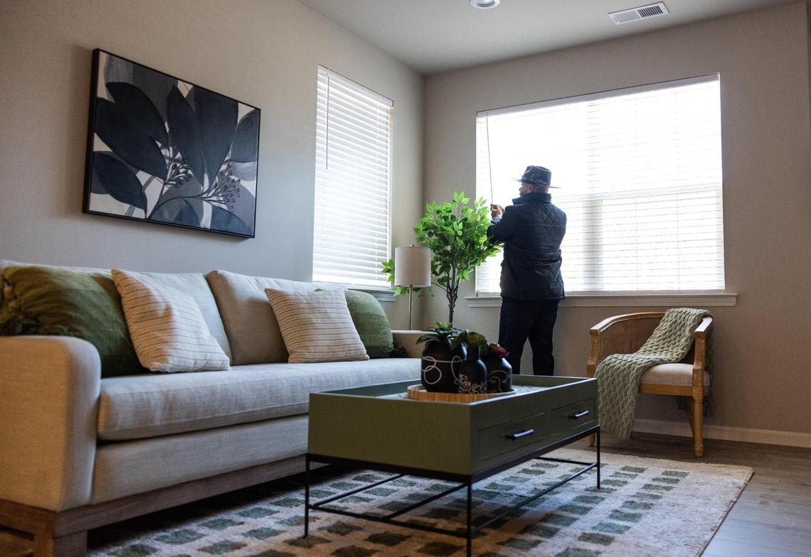 Patrick Graham, CEO of WeBuild Concord, opens the blinds in the living room of one of the newly built Lincoln Street Townhomes in Concord’s Logan neighborhood on Tuesday, January 14, 2025.