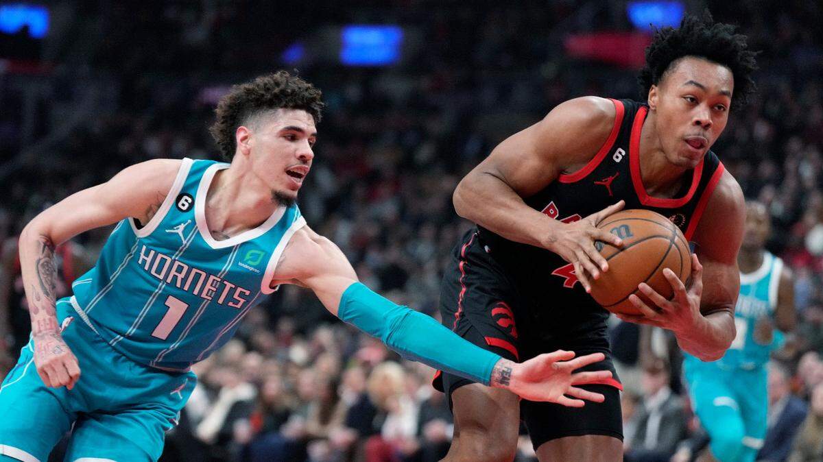 Toronto Raptors forward Scottie Barnes (4) picks up a loose ball as Charlotte Hornets guard LaMelo Ball (1) defends during the first half of an NBA basketball game Thursday, Jan. 12, 2023, in Toronto. (Frank Gunn/The Canadian Press via AP)