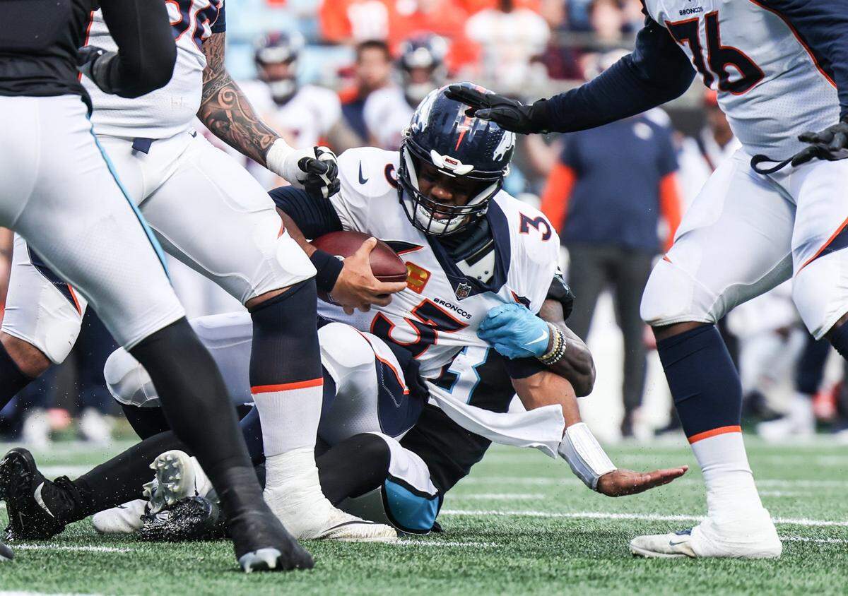 Denver Broncos quarterback Russell Wilson is sacked by a Carolina Panthers defender at the Bank of America Stadium in Charlotte, N.C., on Sunday, November 27, 2022.