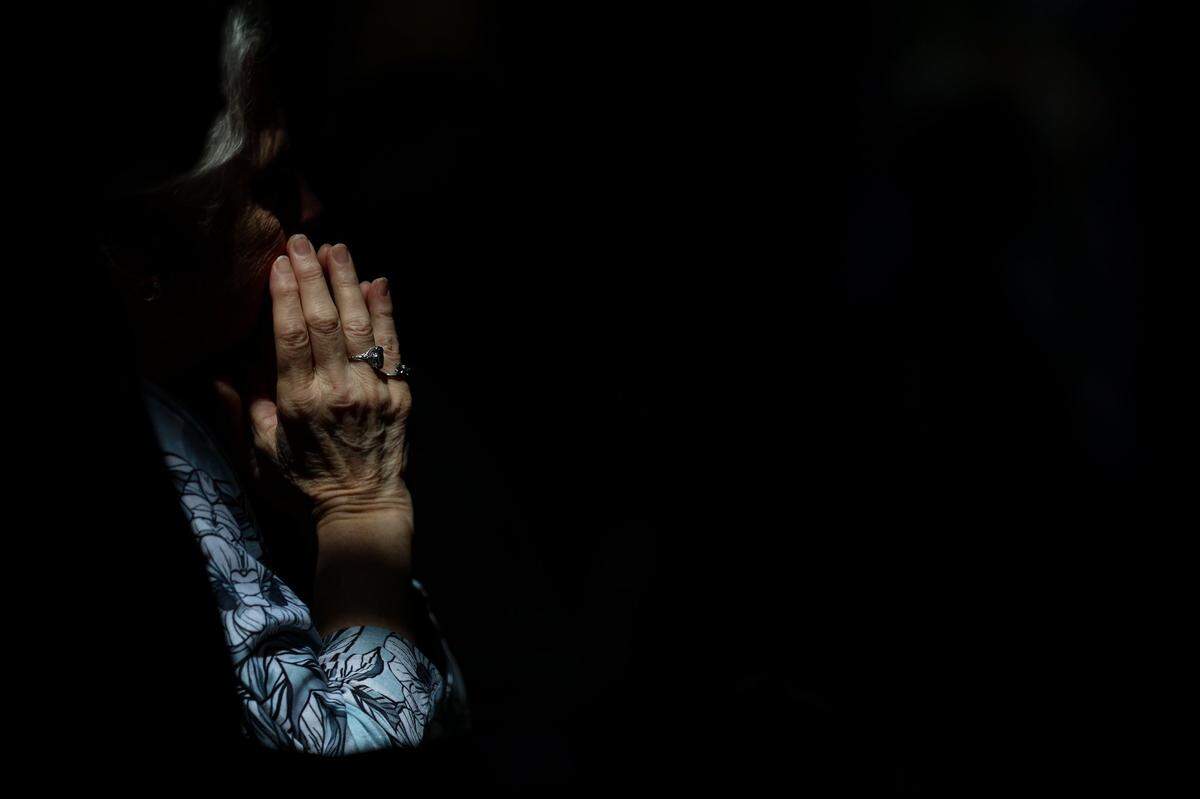An attendee prays during Michael T. Martin’s ordination at Saint Mark Catholic Church in Huntersville on Wednesday, May 29, 2024.