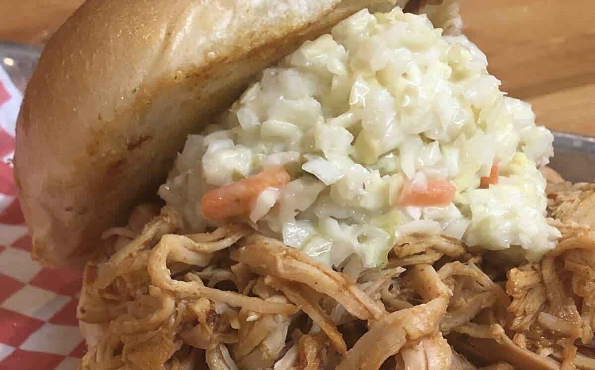 The Crazy Pig’s signature barbecue sandwich comes with pulled pork, slaw and pickles, plus your choice of side ($12).