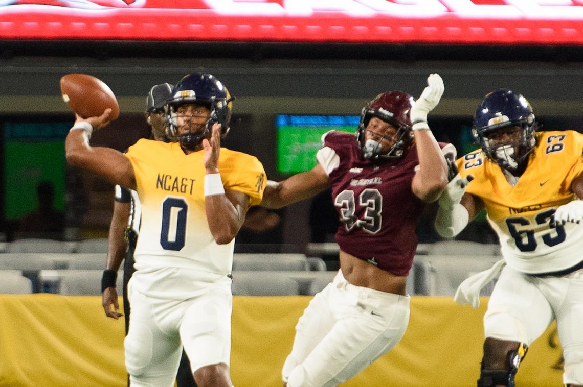 N.C. Central defensive lineman Tre Turner (33) pressures N.C. A&T quarterback Zach Yeager (0) during the Duke’s Mayo Classic at Bank of American Stadium in Charlotte, NC, on Saturday, Sept. 3, 2022. N.C. A&T offensive lineman Ricky Lee III (63) gives chase.