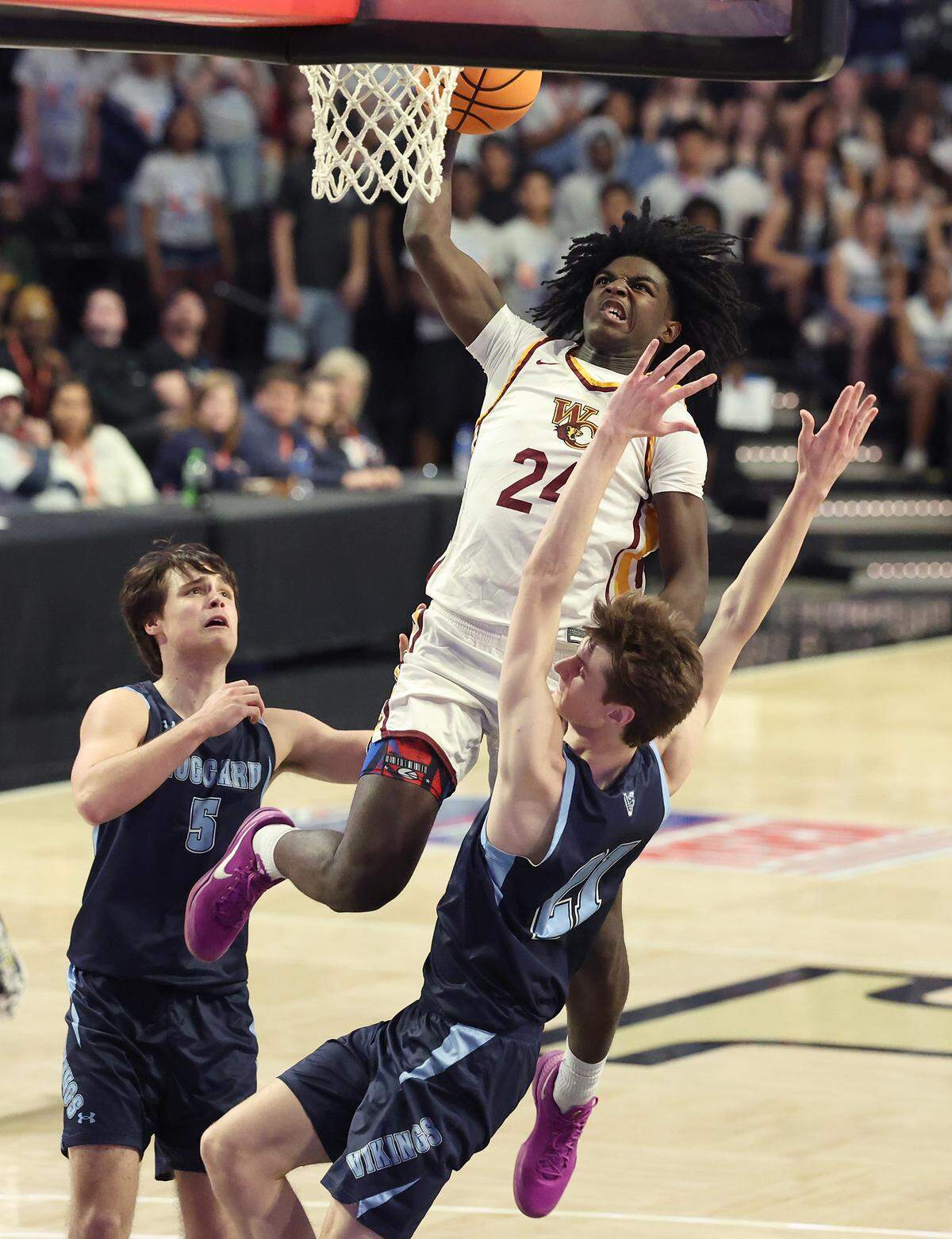 West Charlotte Lions Kaharri Coleman, center, rises to the rim as he splits the Hoggard defense during action in the NCHSAA 8A state championship game at Lawrence Joel Veterans Memorial Coliseum in Winston-Salem, NC on Wednesday, March 11, 2026. West Charlotte defeated Hoggard 70-68.