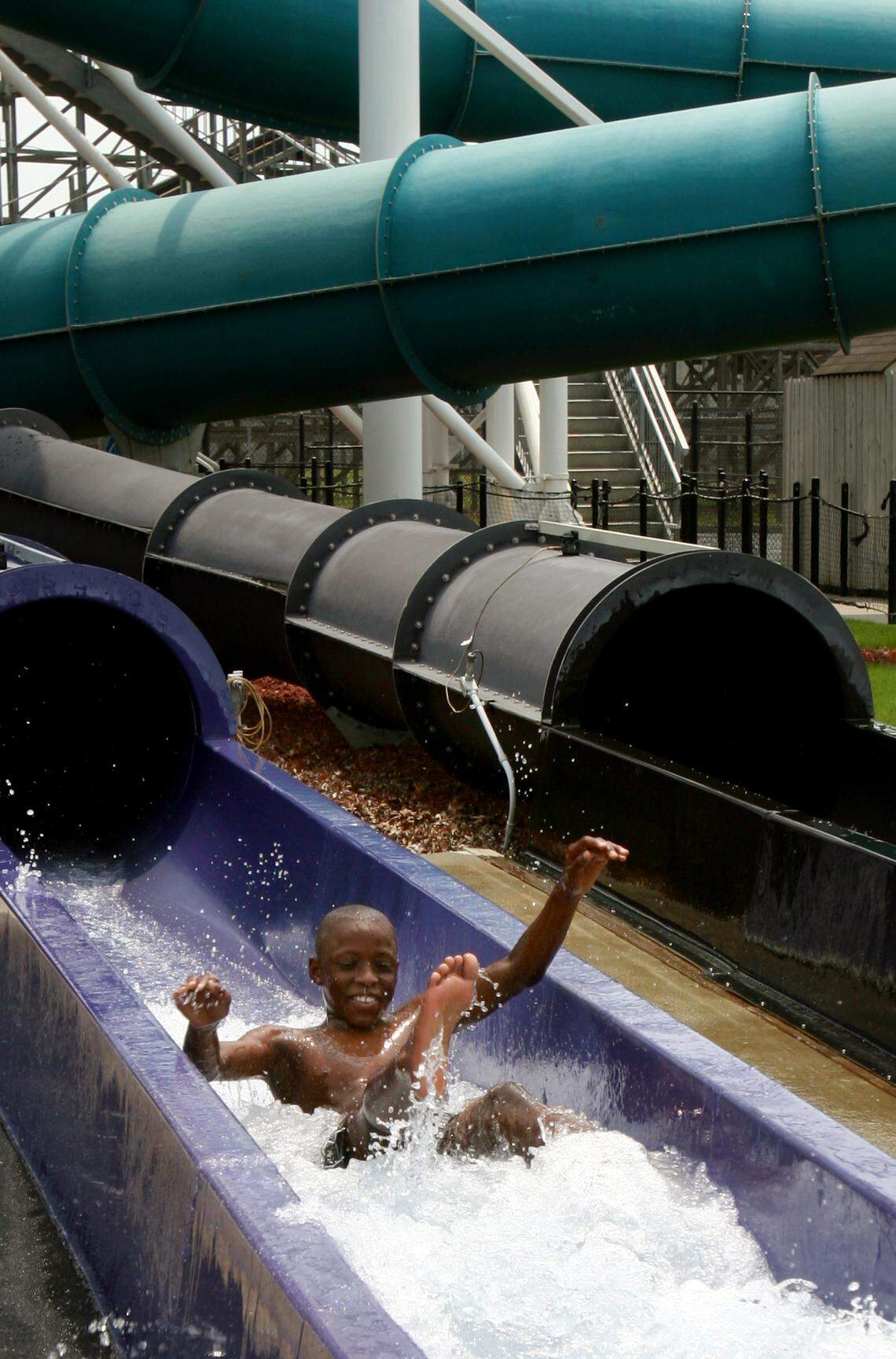 Photo from July 11, 2006: Shawn Williamson, 11, bursts out of a tube on Pipeline Peak, the fastest slide at the time, at Carowinds Boomerang Bay water park.  