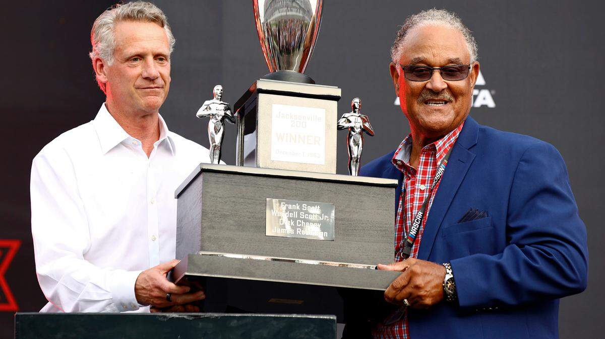 NASCAR President Steve Phelps, left, presents the family of NASCAR Hall of Fame driver Wendell Scott with a trophy for the 1963 Jacksonville 200 win onstage prior to the NASCAR Cup Series Coke Zero Sugar 400 at Daytona International Speedway on Saturday, Aug. 28, 2021, in Daytona Beach, Fla. (Jared C. Tilton/Getty Images/TNS)