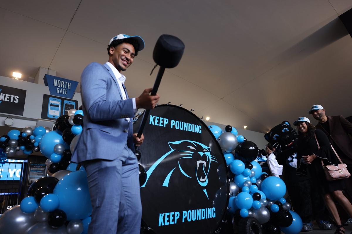 Carolina Panthers QB Bryce Young gets ready to pound the drum before making his way into the Bank of America Stadium Friday morning, April 28, 2023. Fans gather at the North Gate to welcome Young to Charlotte.