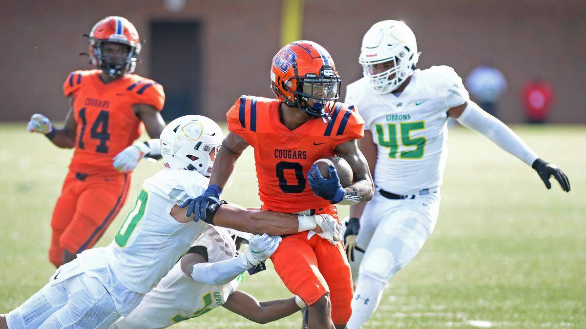 Chambers wide receiver Zion Booker, center, fights for yardage following a pass reception during action against Cardinal Gibbons on Saturday, August 20, 2022 at District 3 Stadium in Rock Hill, SC.