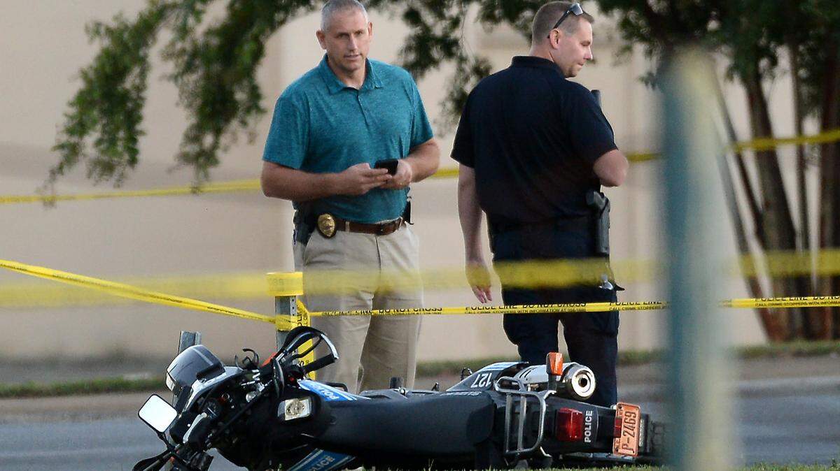 Charlotte-Mecklenburg police investigators stand near the motorcycle of an officer who was involved in a shooting on Tyvola Road in Charlotte, NC, on Thursday, September 23, 2021. The shooting happened near the intersection of South Boulevard.