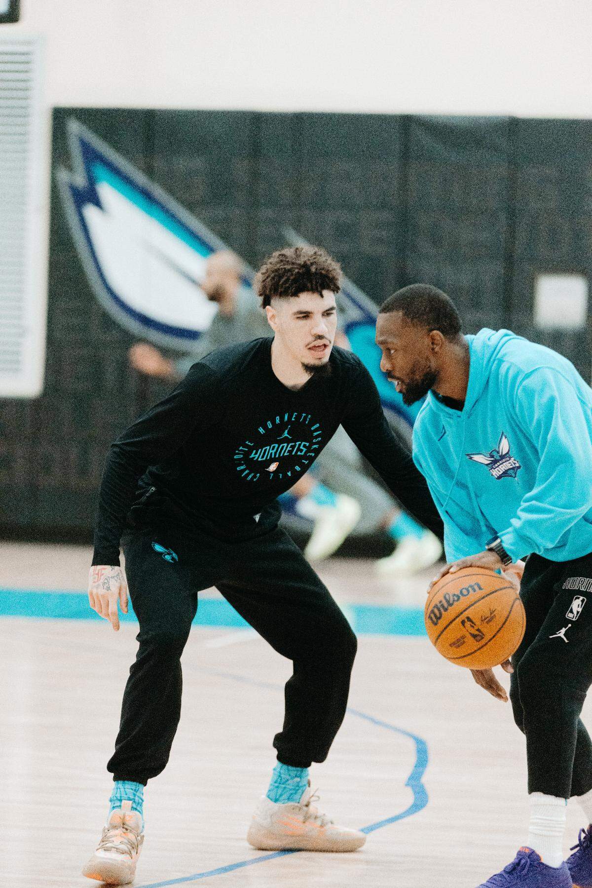 Charlotte Hornets player enhancement coach Kemba Walker works with LaMelo Ball during practice.