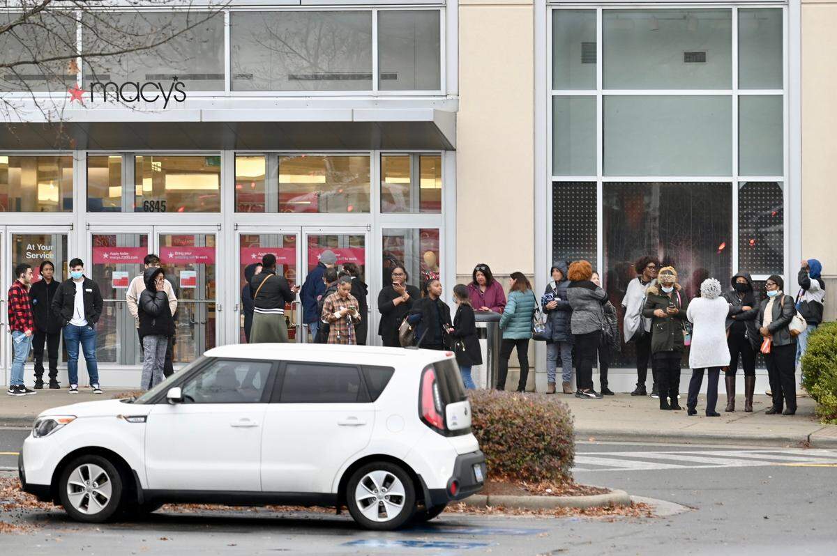 People stand outside Macy’s at Northlake Mall following a reported shooting.