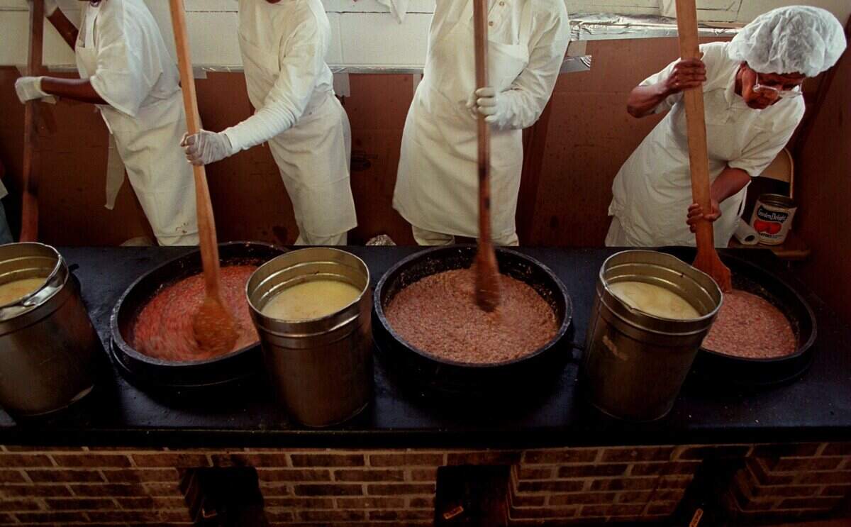 On Oct. 24, 1997, Lucile Moungle (right), 68, stirs a 5-gallon pot of Brunswick stew at the Mallard Creek Barbecue.