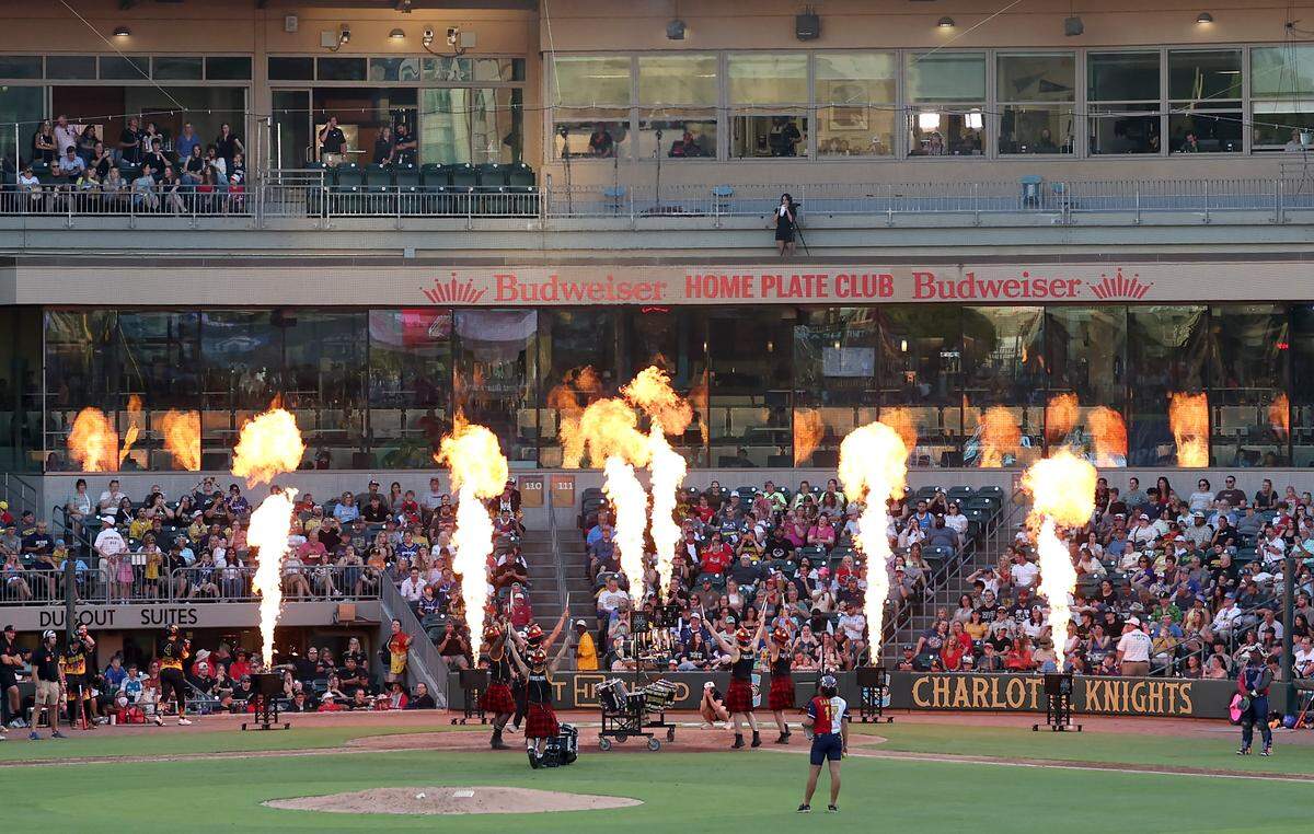 Flames shoot into the sky as members of the Fireline perform during a break in the Texas Tailgaters vs Firefighters game at Truist Field in Charlotte, NC on Thursday, June 4, 2026. Banana Ball action returned to the Queen City with the Texas Tailgaters battling the Firefighters.