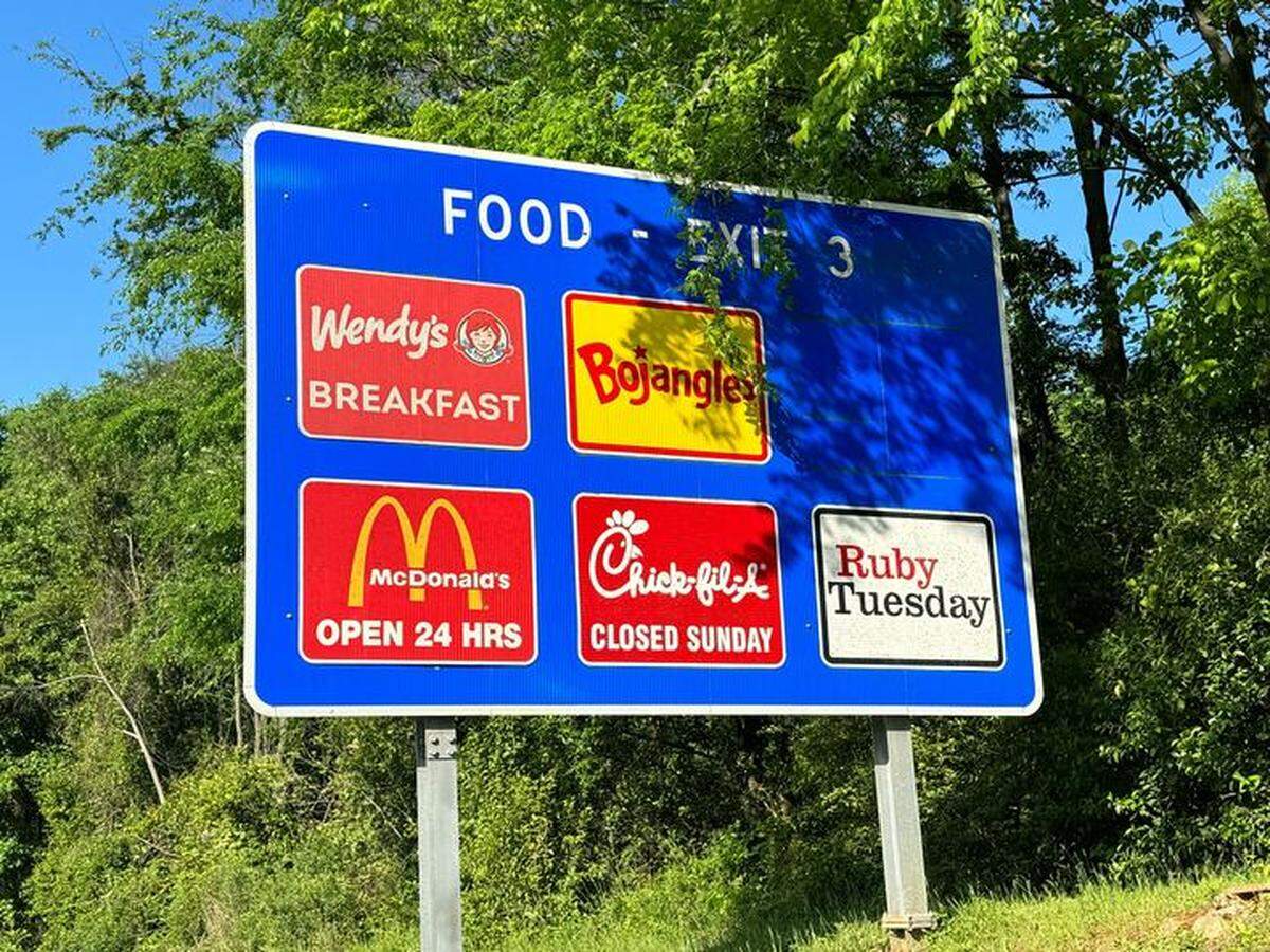 A highway sign shows the fast food options at Exit 3 on I-77 in Charlotte.
