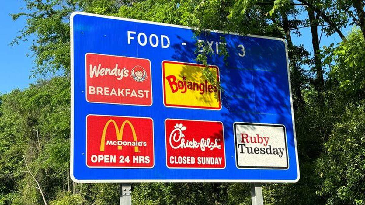 A highway sign shows the fast food options at Exit 3 on I-77 in Charlotte.
