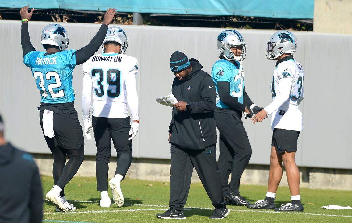 Carolina Panthers offensive coordinator Jeff Nixon, center, looks over his notes during practice on Wednesday, December 15, 2021.