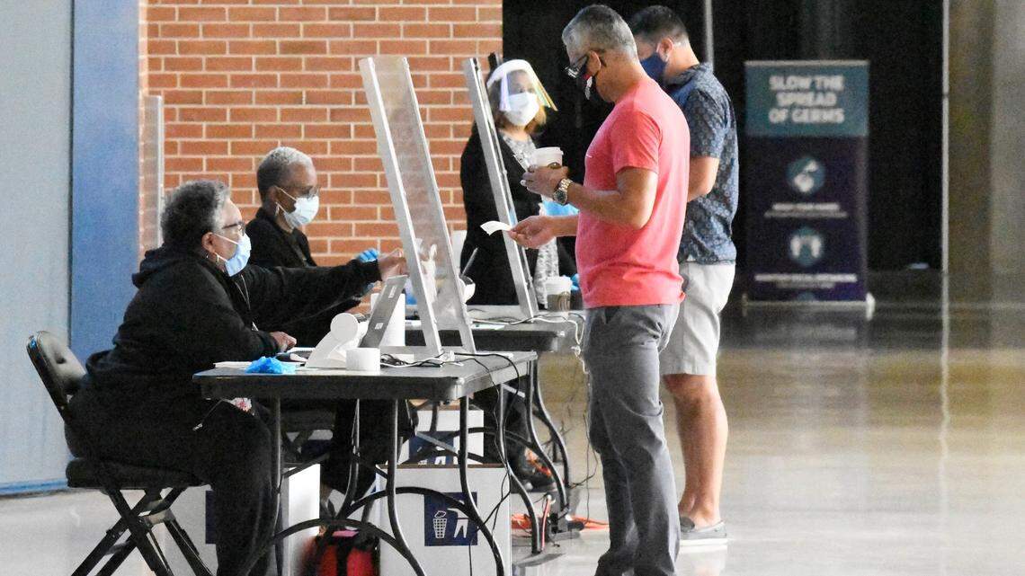 Voters check-in at the Spectrum Center early-voting site on Oct. 15, 2020 in Mecklenburg County. Starting in September 2023, all North Carolina voters will be asked to show photo ID when voting.