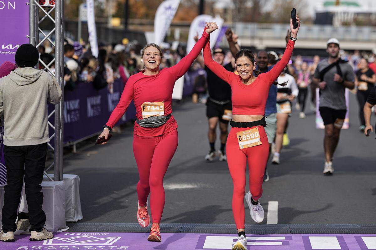 Participants celebrate after competing in the Novant Health Charlotte Marathon Saturday, Nov. 15, 2025, in Charlotte, N.C.