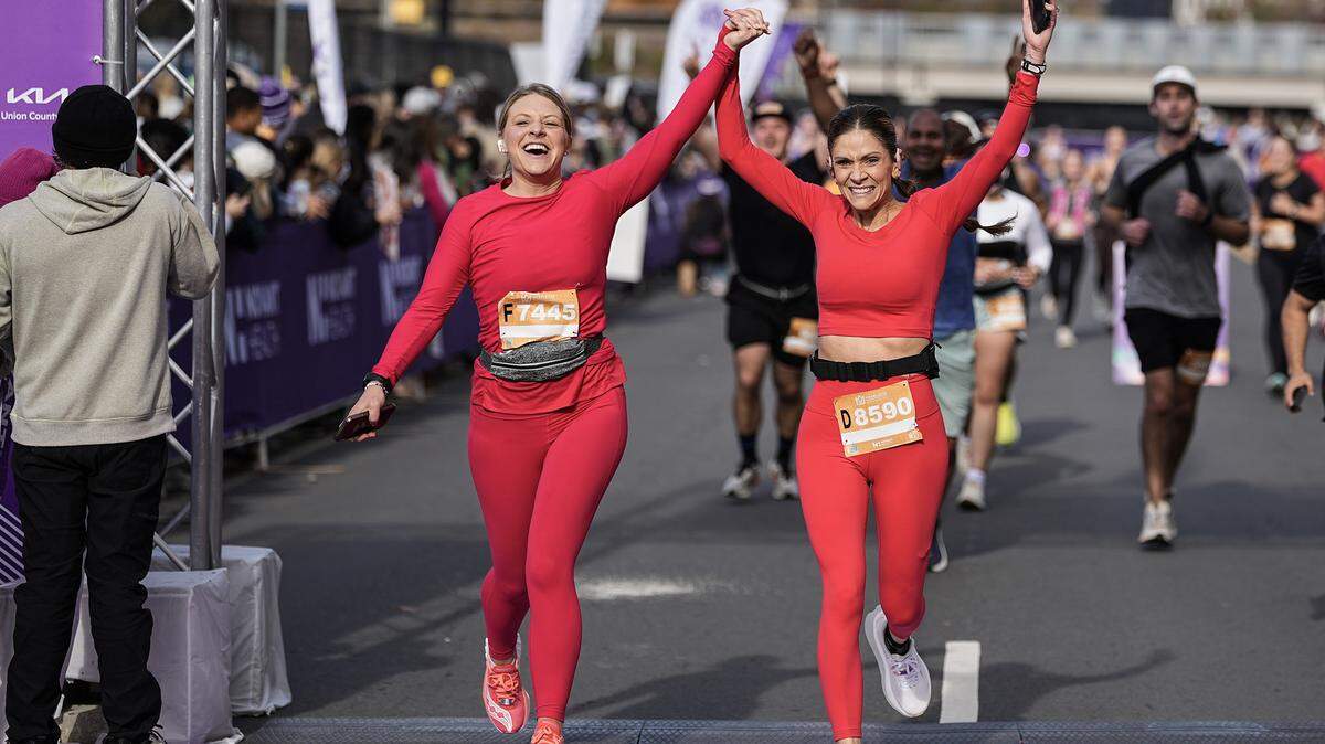 Participants celebrate after competing in the Novant Health Charlotte Marathon Saturday, Nov. 15, 2025, in Charlotte, N.C.