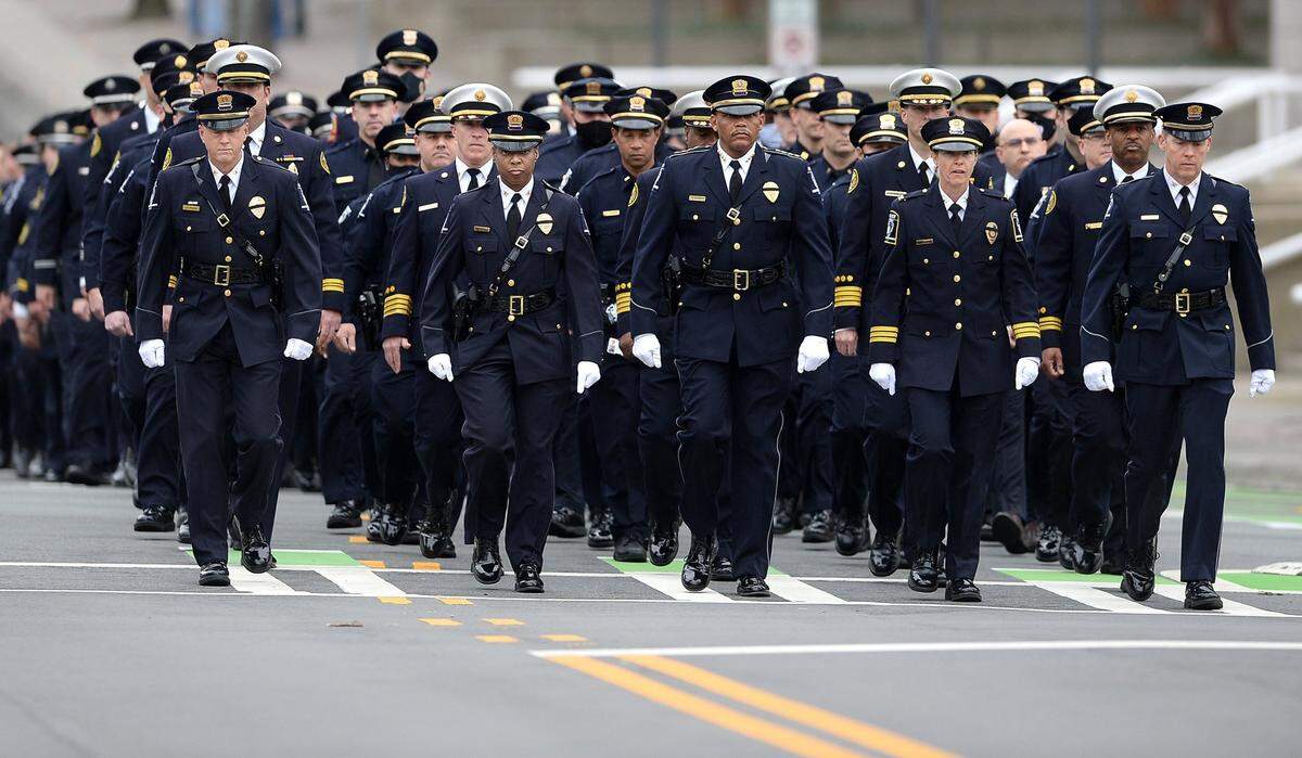 Charlotte-Mecklenburg Police Chief Johnny Jennings, center, marches with a group of CMPD officers down South Davidson St. in Charlotte, NC to First Baptist Church on Wednesday, December 29, 2021. CMPD officials and officers along with Charlotte Fire Department personnel came to mourn and honor the loss of CMPD Officer Mia Goodwin was killed while responding to a crash on Interstate 85 on December 22, 2021.