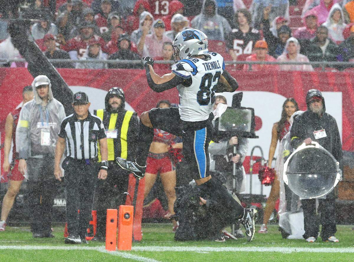 Carolina Panthers tight end Tommy Tremble leaps into the air as he crosses the goal line to score a touchdown during action against the Tampa Bay Buccaneers at Raymond James Stadium in Tampa, FL.on Saturday, January 3, 2026. 
