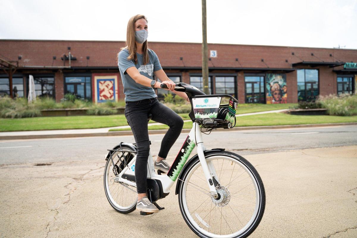 Alli Cruse sits on a Charlotte Joy Rides bicycle, which has a new pedal-assist battery to help riders get around easier.