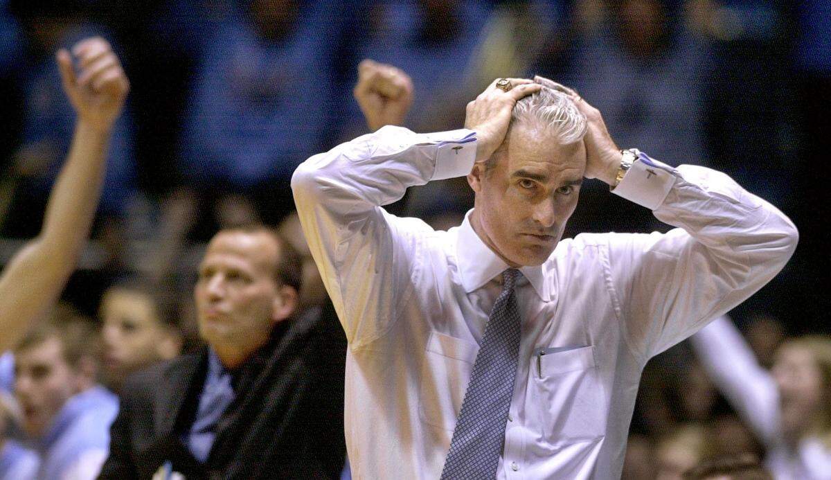 UNC head coach Matt Doherty watches a last second desperation shot by Florida State fall short as the Tar Heel squeak out a 61-60 win to stop their five game losing streak in 2003.