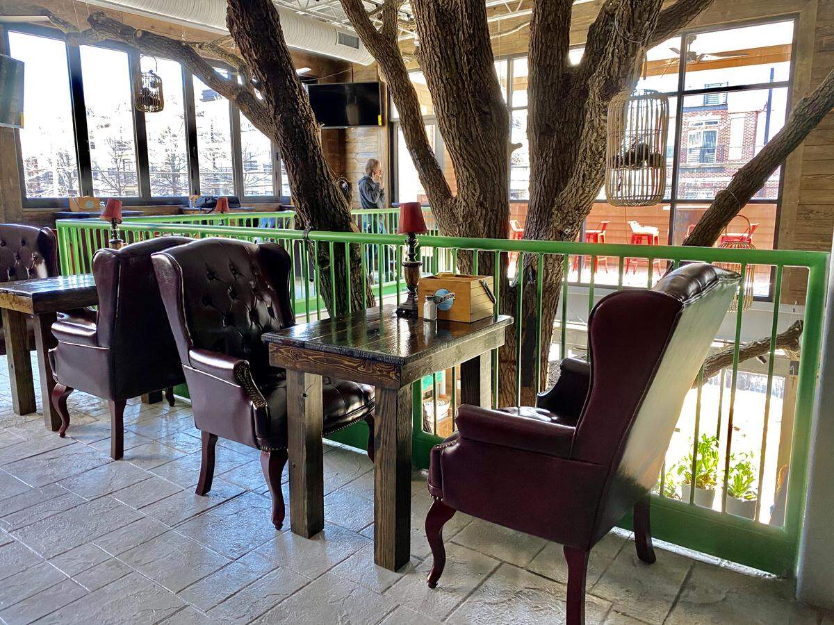 Charlotte Beer Garden feels like a treehouse, with an actual tree in the center, complete with bird cages.
