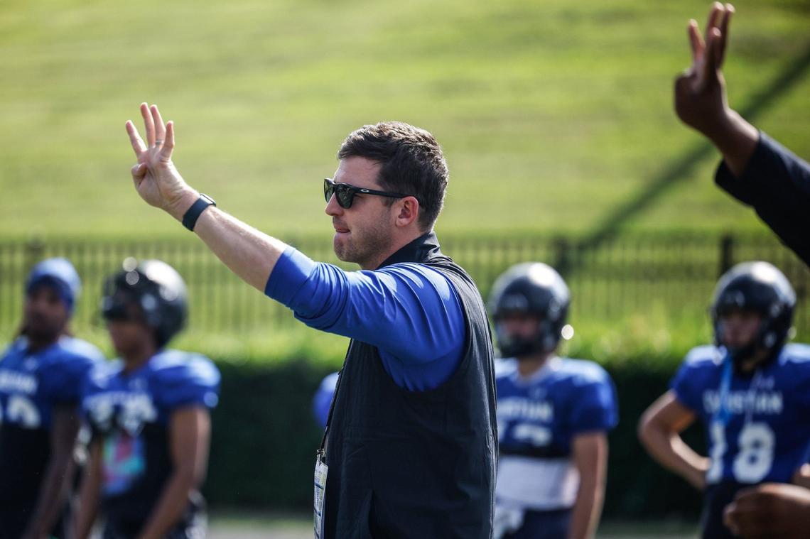 Charlotte Christian head coach Chris James holds up a signal during football practice on Wednesday, August 22, 2024.