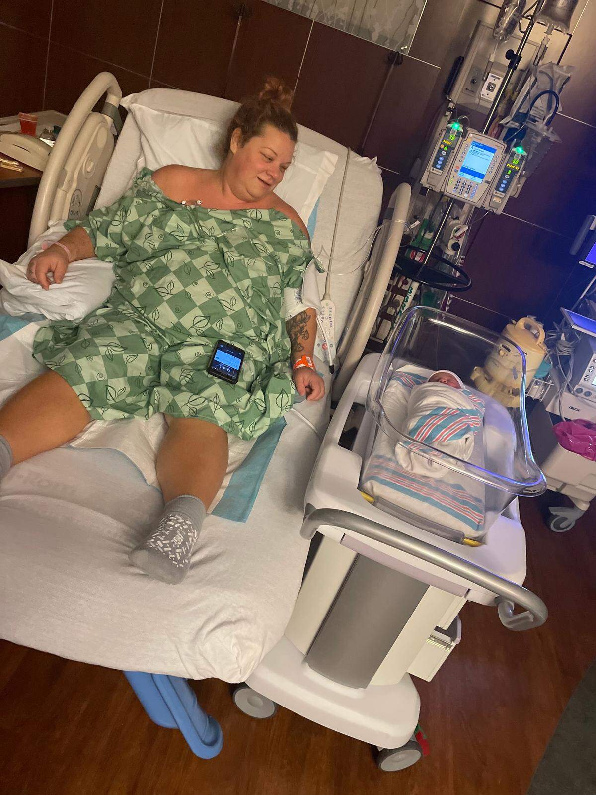 Erin O’Malley lies in a bed at Novant Health Matthews hospital next to her newborn daughter.