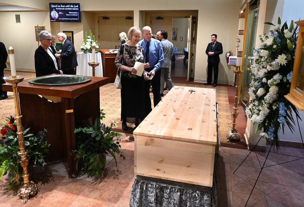 Mourners stop and pay respects to former longtime Charlotte Motor Speedway president H.A. “Humpy” Wheeler, Jr., prior to his funeral on Tuesday, August 26, 2025 at St. Gabriel Catholic Church in Charlotte, NC. At Wheeler’s request, he was buried in a simple casket made of pine wood.