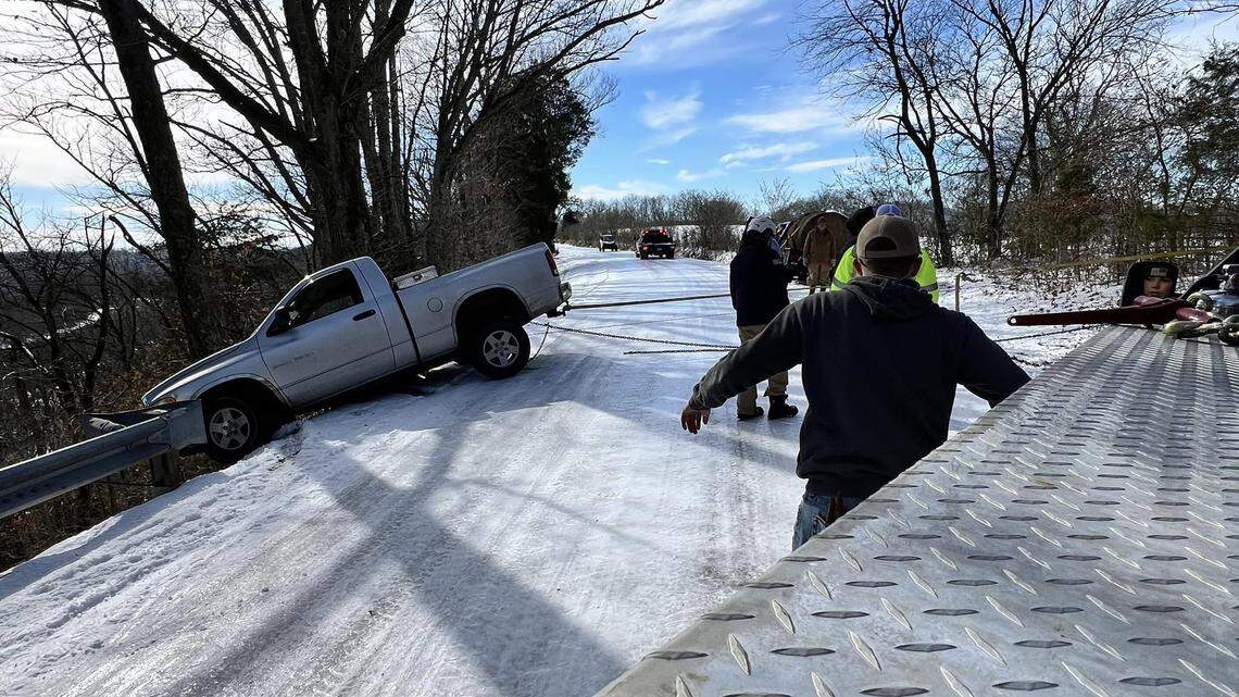 The driver was forced to remain seated in the truck until it could be winched onto the road by a fire department vehicle, officials said.