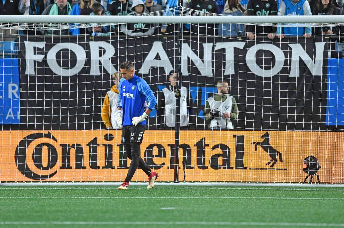 Feb 25, 2023; Charlotte, North Carolina, USA; Charlotte FC goalkeeper Pablo Sisniega (23) reacts as a banner honors the memory of late Charlotte FC player Anton Walkes before a match against the New England Revolution at Bank of America Stadium. Mandatory Credit: Griffin Zetterberg-USA TODAY Sports