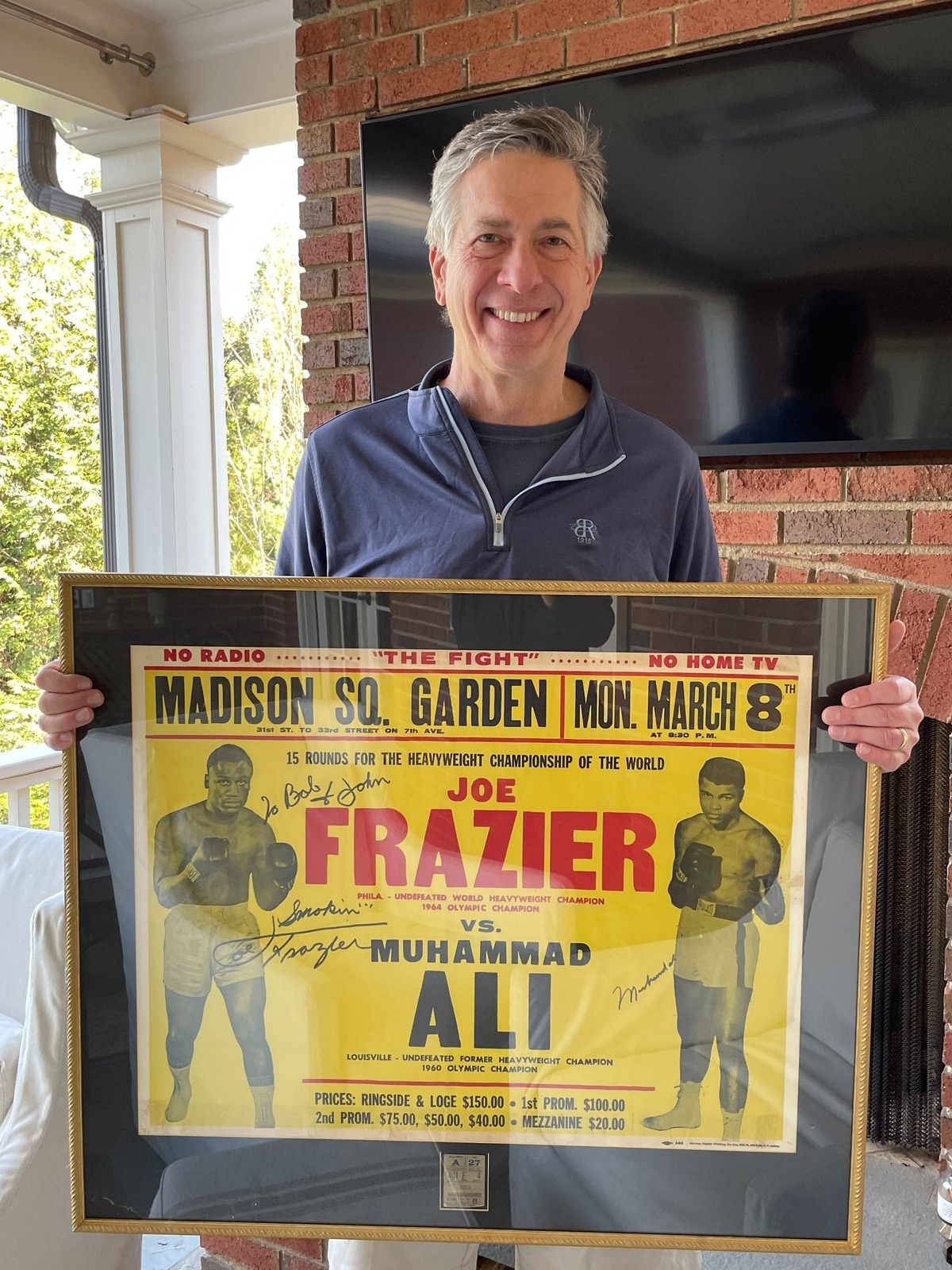 Charlotte doctor John Allbert holds a copy of a poster from the Muhammad Ali-Joe Frazier fight from March 8, 1971. In 2001, Allbert was able to get both fighters to sign the poster and gave it to his father - who took him to the fight - as a gift.