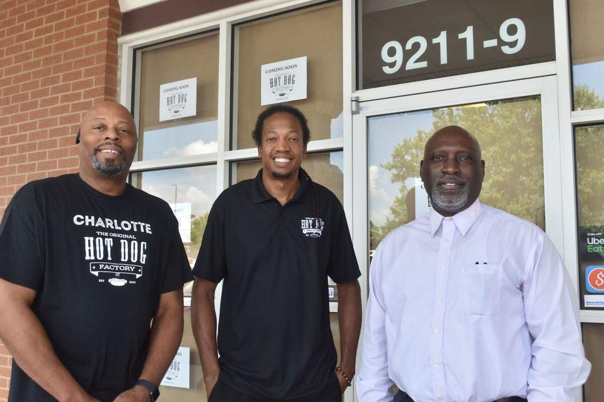 Anthony Marc Hailey, Sherod McNealy and Michael Hailey stand outside the Original Hot Dog Factory of Charlotte in University City.