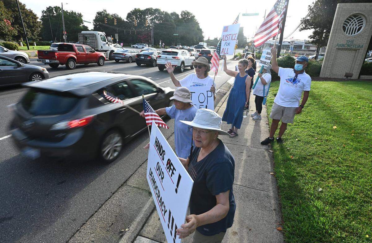 Indivisible Charlotte supporters stand along Hwy 51 and Providence Road Thursday morning, July 17, 2025. The group along with hundreds of communities across the country are coming together to honor the legacy of Congressman John Lewis with “Good Trouble Lives On” Day of Action demonstrations.