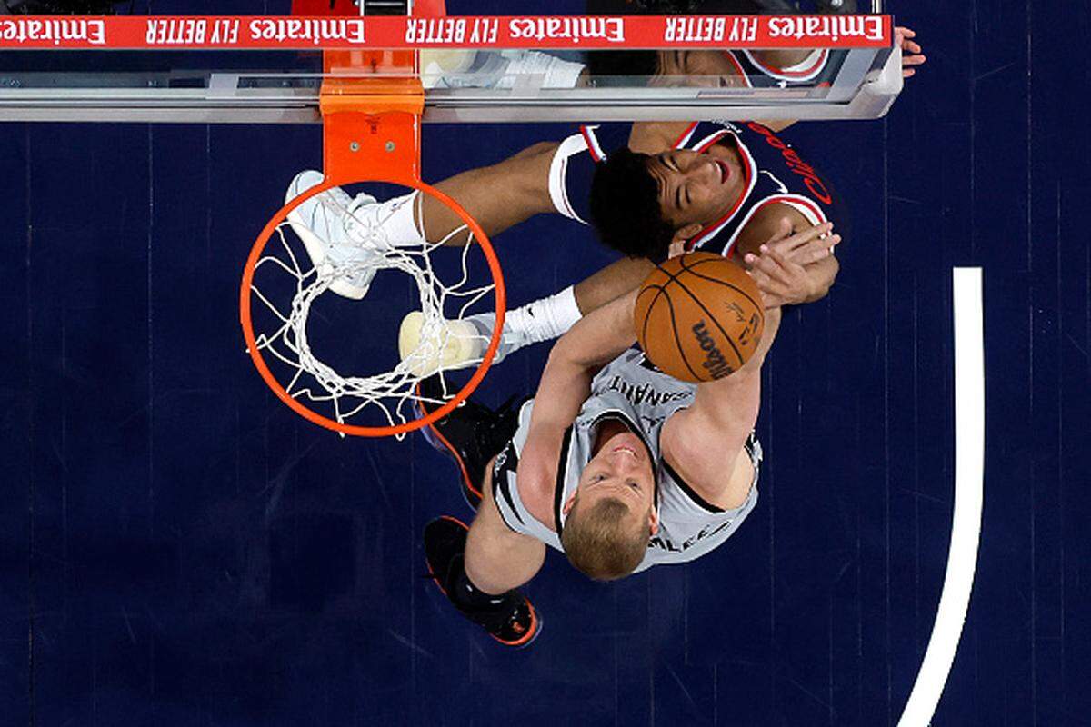 Cam Christie of the Los Angeles Clippers shoots past the defense of  Mason Plumlee of the San Antonio Spurs during the first half of a game at Intuit Dome.