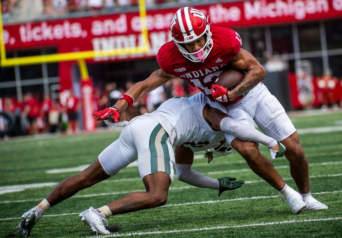 Indiana’s Elijah Sarratt (13) fights for yards against the Charlotte 49ers’ defense at Memorial Stadium in Bloomington, Ind., on Saturday, Sept. 21, 2024.