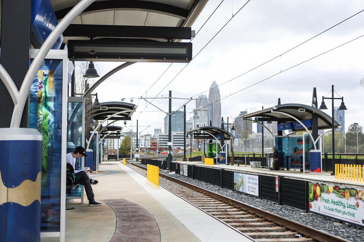 A young man waits at the Parkwood Station for the LYNX Blue Line light rail, heading toward UNC Charlotte in March 2023.