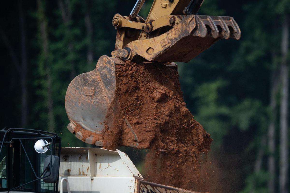 A backhoe moving dirt at a construction site for a 45-classroom elementary school being built as relief for Polo Ridge, Hawk Ridge, and Elon Park elementary schools Friday, July 22, 2022.