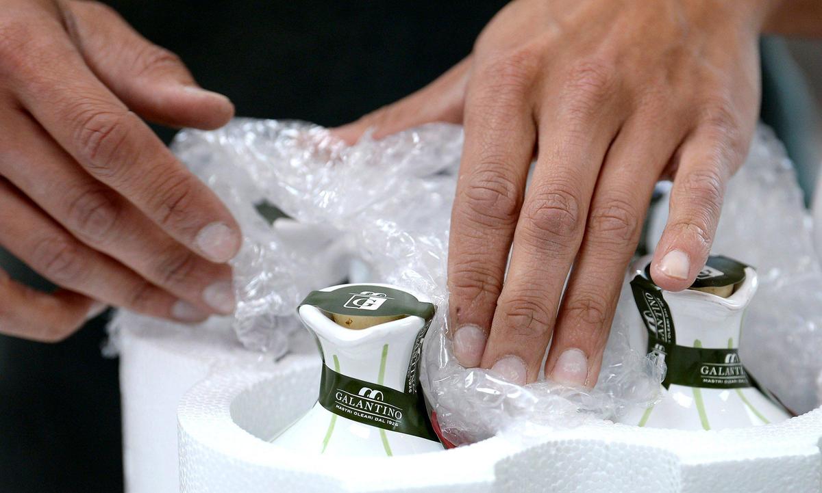 James Jordan, an employee of Zia Pia Imports + Italian Kitchen in Charlotte, packages hand-painted ceramic olive oil containers for shipping Wednesday.