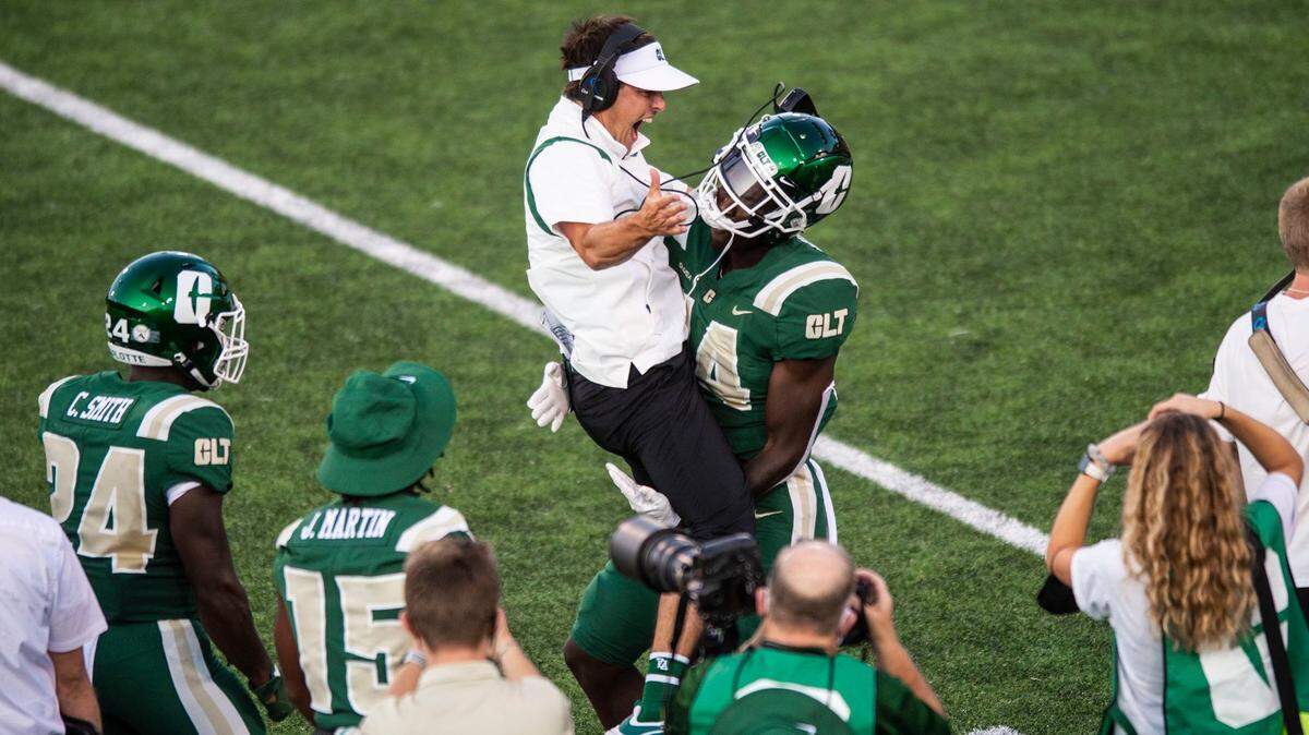 Charlotte 49ers head coach, Will Healy, left center, jumps on wide receiver, Grant DuBose, in jubilation after DuBose scored a touchdown against Duke at Jerry Richardson Stadium on Sept. 3. Charlotte will play Gardner-Webb this week.