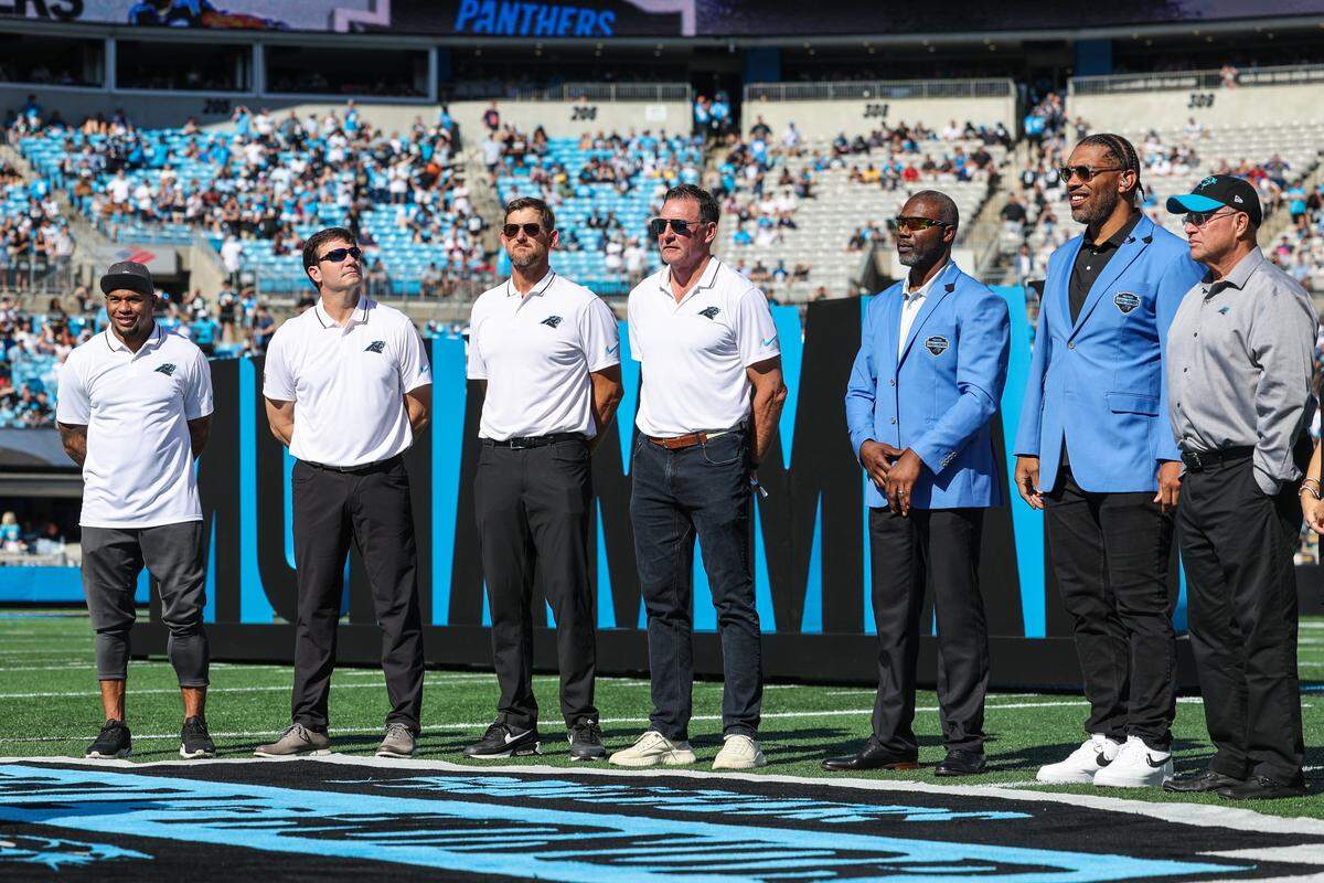 Panthers legends and past Hall of Honor inductees (L to R) Steve Smith, Jake Delhomme, Jordan Gross, Wesley Walls stand next to new inductees Muhsin Muhammad, Peppers and team owner David Tepper at the Hall of Honor induction ceremony at halftime at Bank of America Stadium on Sunday, October 29, 2023.