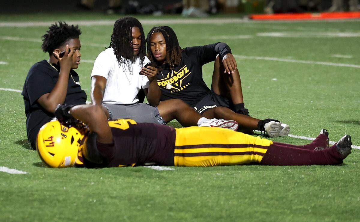 West Charlotte students sit on the field following a chaotic scene that had players and fans scrambling for safety near the start of third quarter action between Mallard Creek and West Charlotte on Friday, September 20, 2024 at West Charlotte High in Charlotte, NC.
