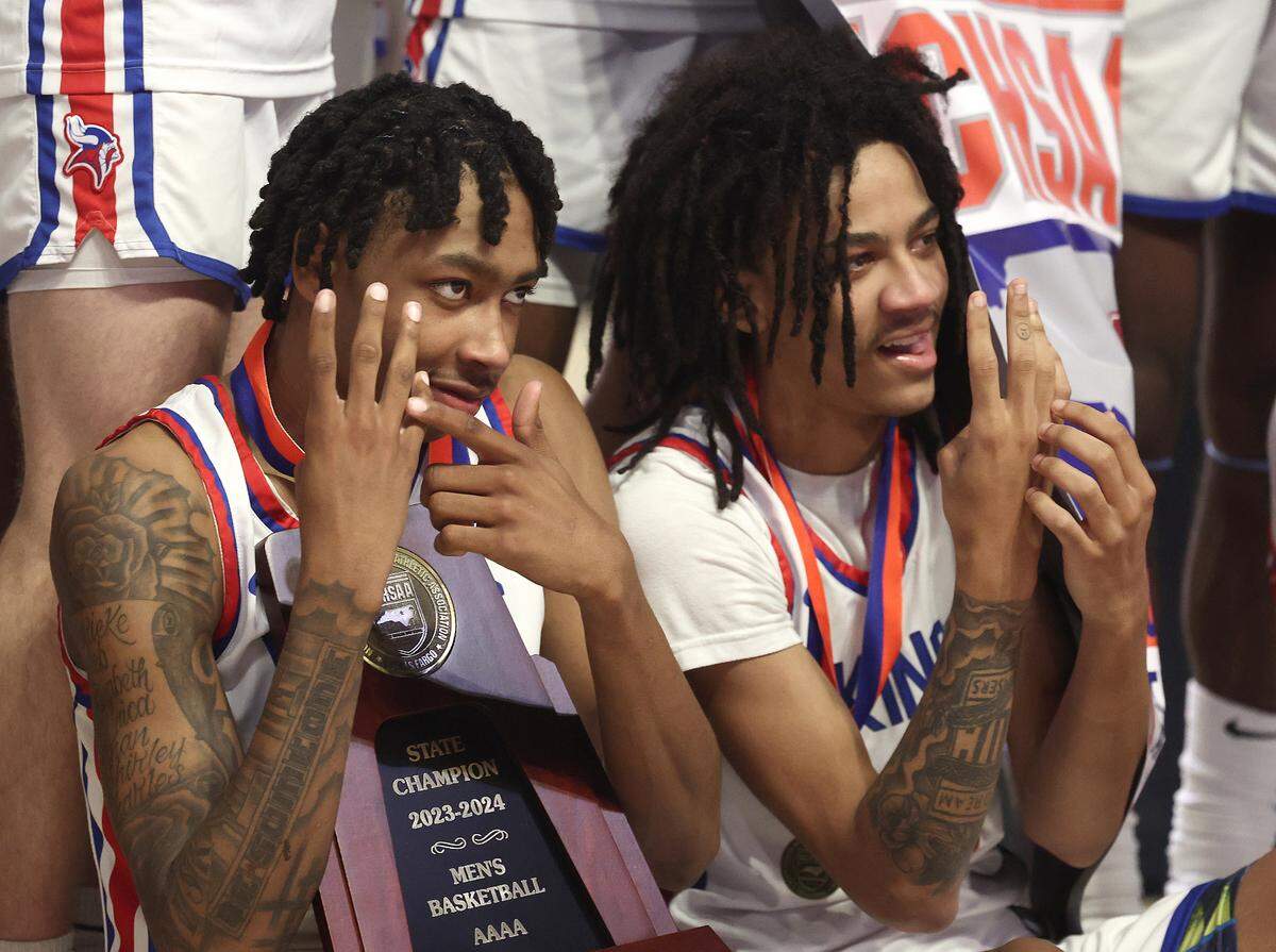 North Meck Vikings Isaiah Evans, left and Trey Maxwell III, right, show their ring finger as they celebrate the team’s 57-47 victory over New Hanover with his team on Saturday, March 16, 2024. The Vikings won the NCHSAA 4A State Championship at Lawrence Joel Veterans Memorial Coliseum in Winston-Salem, NC.