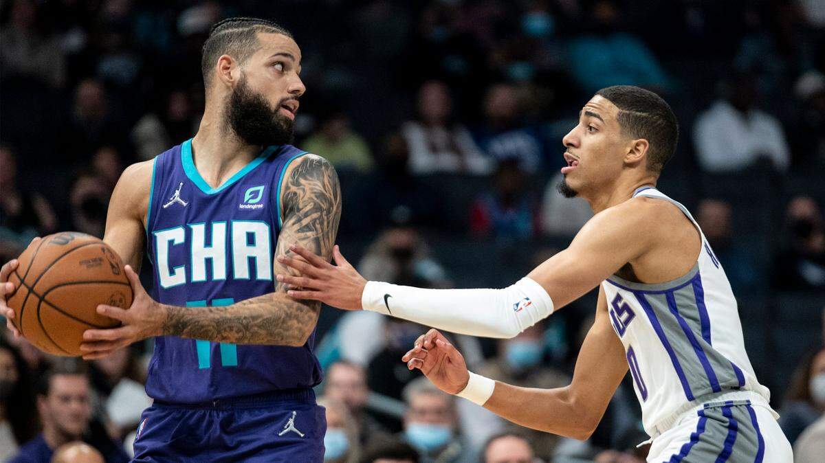 Charlotte Hornets forward Cody Martin (11) is defended by Sacramento Kings guard Tyrese Haliburton (0) during the first half of an NBA basketball game, Friday, Dec. 10, 2021, in Charlotte, N.C. (AP Photo/Matt Kelley)