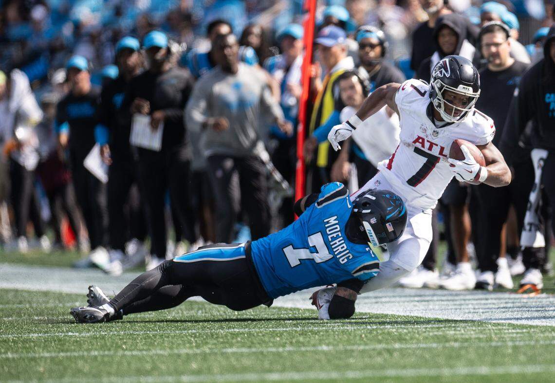 Atlanta Falcons running back Bijan Robinson, right, is tackled by Carolina Panthers safety Tre'von Moehrig at the Bank of America Stadium in Charlotte, N.C., on Sunday, September 21, 2025.