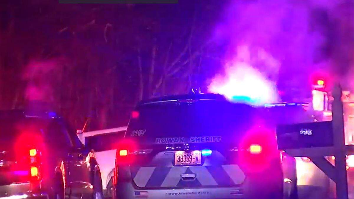 Two police officers and a firefighter were injured when shots were fired as they responded to a house fire in Rowan County overnight. A person inside the house died, according to authorities.