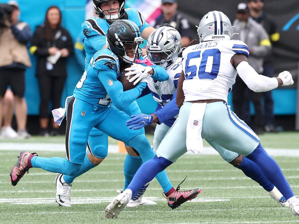 Carolina Panthers wide receiver Jimmy Horn Jr., left, fights for yardage against the Dallas Cowboys defense during action on Oct. 12, 2025. The Panthers defeated the Cowboys 30-27.